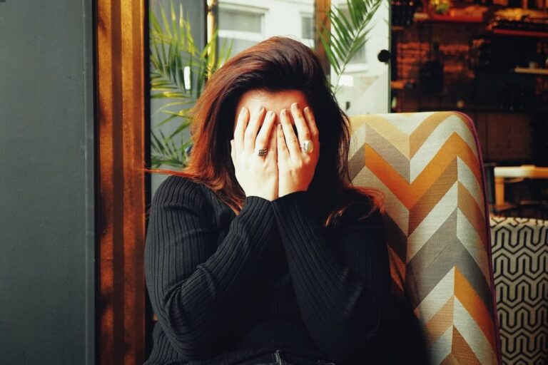 Person covering their face with their hands