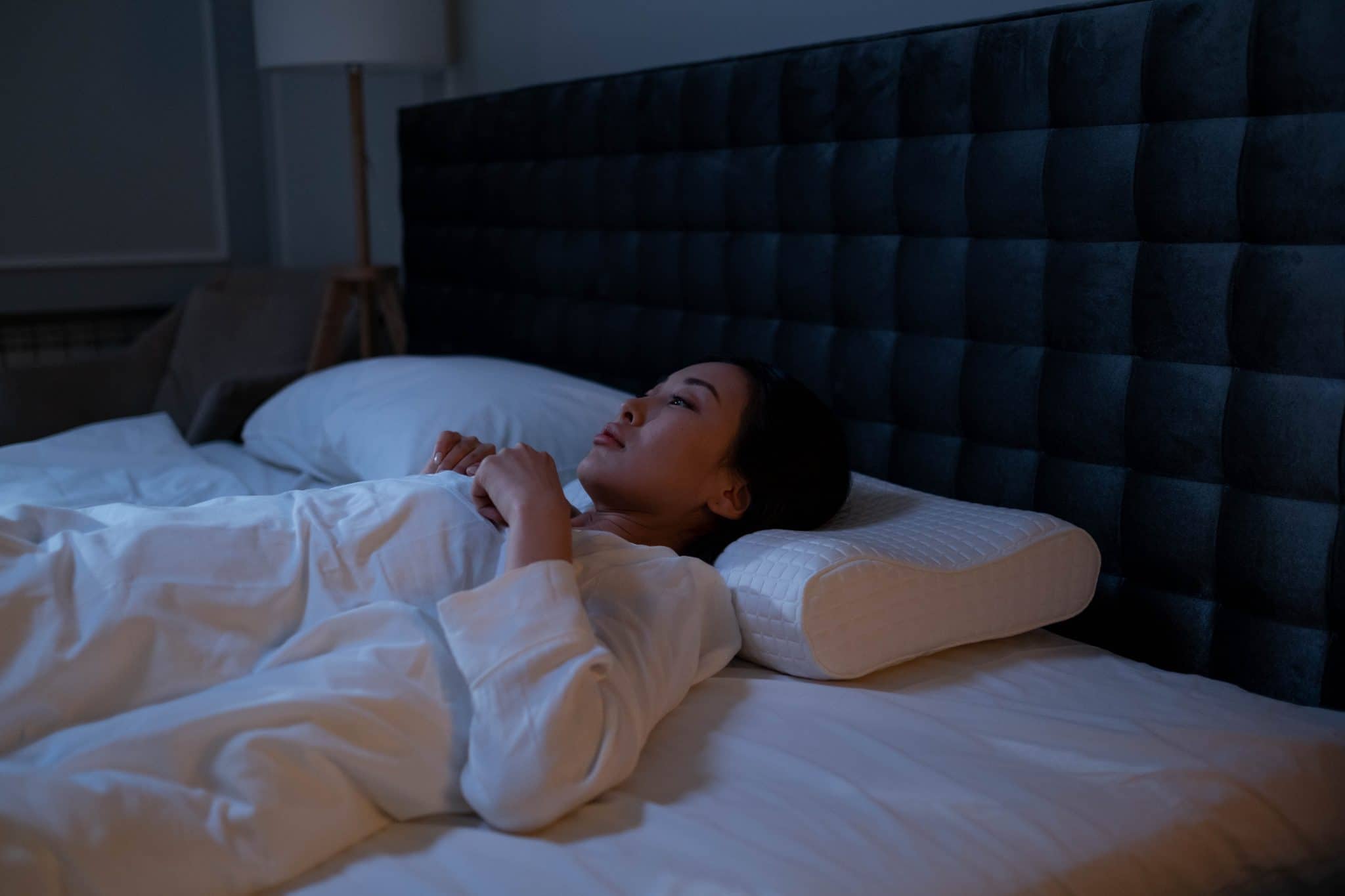 Woman awake in bed at night.